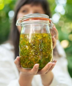 Wzmocniony Macerat Dziurawcowy Klaudyna Hebda świeży macerat z dziurawca w słoiku trzymany w dłoniach