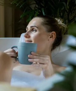 Relaksująca kąpiel - koncentrat Liptus K. Hebda – kobieta odpoczywająca w wannie z kubkiem herbaty