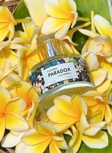 Ekskluzywne perfumy Flower Paradox by K. Hebda otoczone świeżymi, żółtymi kwiatami egzotycznymi.