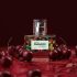 Packshot perfum Cherry Paradox na tle soczystych wiśni