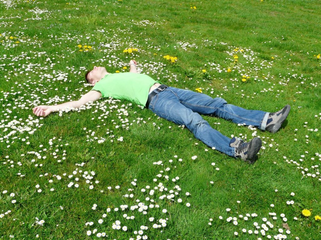 Mężczyzna relaksujący się na trawie i jego naturalne metody ochrony przed kleszczami – klaudynahebda.pl
