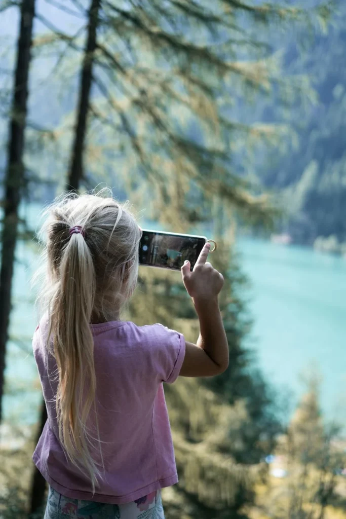 Dziewczynka w lesie z telefonem komórkowym przyciągającym kleszcze- jak się chronić – klaudynahebda.pl