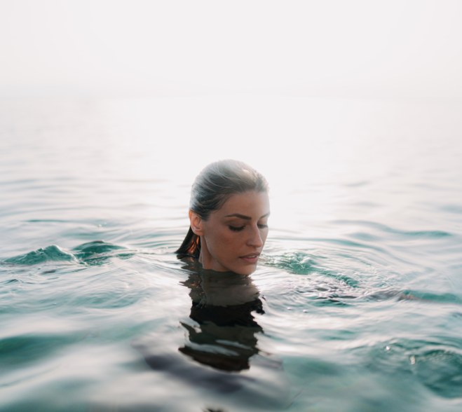 Kobieta zanurzona w czystej wodzie oceanu, symbolizująca ukojenie i harmonię suchego olejku Sea Paradox.