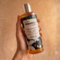 Naturalny olejek pod prysznic Flower Paradox by K. Hebda 250 ml trzymany w dłoni pod prysznicem.