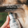 Dłoń trzymająca butelkę Nutta Pets i rozpylająca spray na karku długowłosego psa.